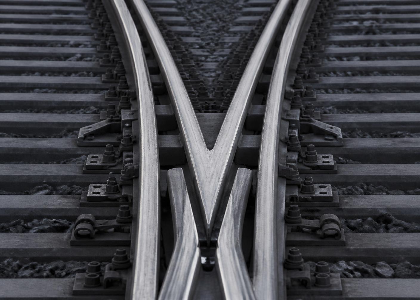 Gros plan sur un aiguillage de voie ferrée montrant des rails d'acier qui se croisent